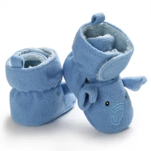 Dettaglio scarpine neonato in pile blu con ricamo a forma di simpatico elefante e velcro.