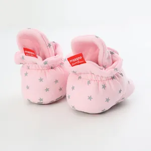 Detail of pink baby walking shoes with silver star patterns and an elastic cuff.