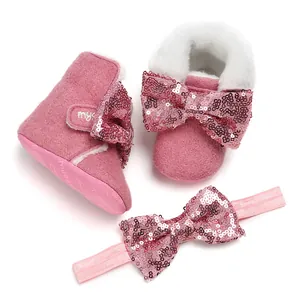 Detailansicht der rosa Pailletten-Schleifen-Babystiefel mit passendem Stirnband