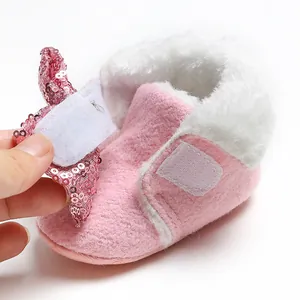 Detailansicht des rosa Paillettenriemens und Klettverschlusses an warmen Babystiefeln