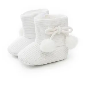 Bottines tricotées blanches pour bébé avec semelles souples et pompons