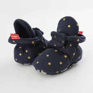 Macro view of navy baby booties with gold star pattern and elasticated ankle detail