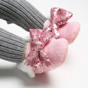 Detailansicht von rosa Baby-Fleeceschuhen mit Paillettenschleife und weichem Kunstfell.