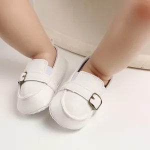 Primo piano di scarpe bianche primi passi per neonati con fibbia in metallo retrò