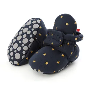Detailed view of navy blue baby booties with gold star patterns and anti-slip soles