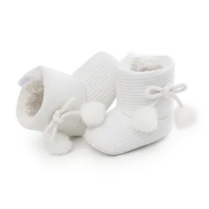 Bottines tricotées blanches pour bébé avec doublure en peluche et pompons pour marcher.