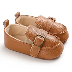 Dettaglio di scarpe da bambino in pelle marrone con suola morbida e fibbia vintage