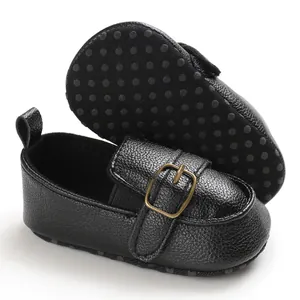 Primo piano di scarpe primi passi per neonati nere con suola morbida antiscivolo.