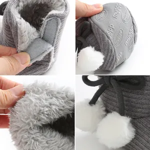 Détails des chaussons de bébé en tricot gris avec pompons blancs et doublure en fourrure.