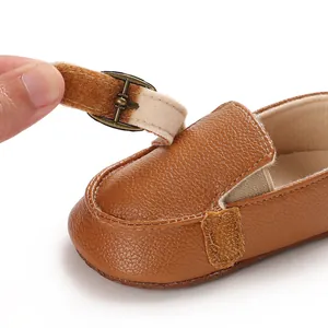 Dettaglio scarpa primi passi neonato in pelle marrone con cinturino in velcro e fibbia