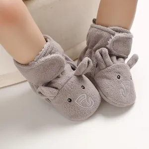 Primo piano di morbidi stivaletti in peluche grigio per neonati con design a elefante
