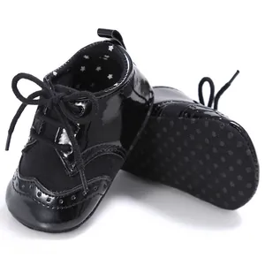Close-up of black patent leather baby shoes with brogue detailing and star lining