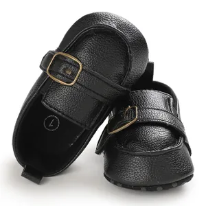 Dettaglio di scarpe da camminata per neonati in ecopelle nera con suola morbida e fibbia