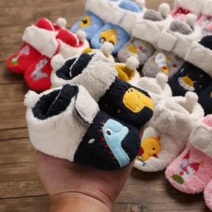 Close-up of soft fleece baby shoes featuring cute cartoon dinosaur embroidery and warm lining