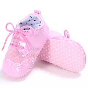 Soft pink infant pre-walker shoes featuring non-slip dotted soles and a cute lace-up design