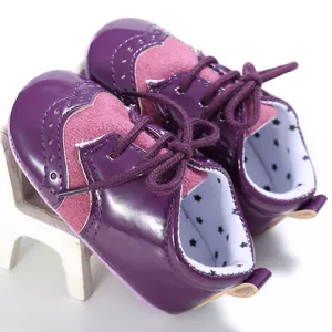 Close-up of purple and pink brogue style baby pre-walker shoes with star pattern lining