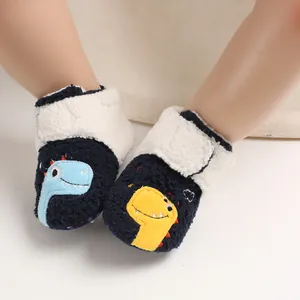 Close-up view of navy blue fleece baby winter booties with cute cartoon dinosaur design