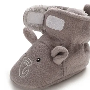 Dettaglio macro di scarponcini neonato in peluche grigio con ricamo a forma di elefante