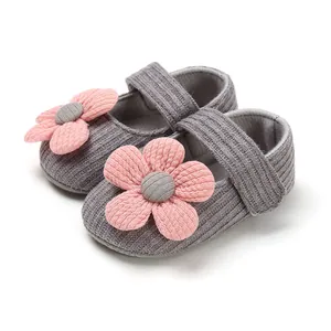 Close-up of pink knit flower decoration on grey soft-soled baby girl princess shoes