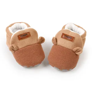 Close-up of warm brown baby booties with soft fleece lining and cute animal ear design.