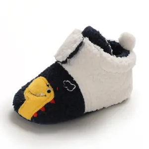 Close-up detail of fleece baby walking shoes featuring a cute cartoon dinosaur motif