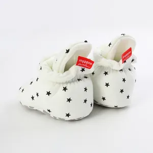Detailed rear view of white baby star print booties featuring a red brand logo tag