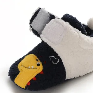 Close-up of soft fleece baby walker shoes with cute yellow dinosaur embroidery detail