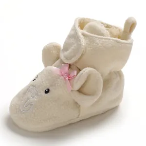 Dettaglio scarpine neonato in pile panna con ricamo elefante e fiocco rosa ornamentale.