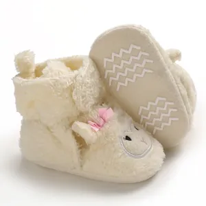 Dettaglio scarpine neonato in peluche crema a forma di pecora con suola morbida antiscivolo