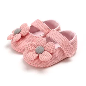 Detail of pink knitted baby shoes with flower decor and soft soles for infants