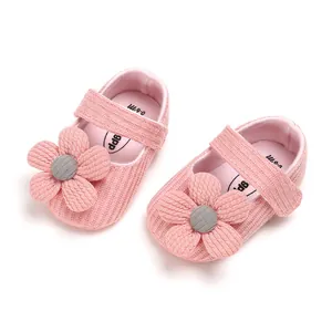 Close-up of pink knitted baby girl princess shoes with decorative flower design