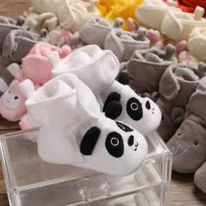 Primo piano dettagliato di scarpe primi passi per neonati in peluche con design panda.