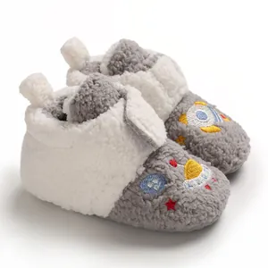 Close-up detail of cozy fleece-lined baby boots with rocket embroidery for winter