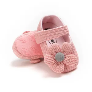 Detailed view of pink knitted baby princess shoes with 3D flower decoration
