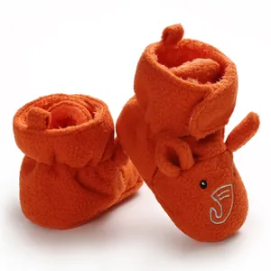 Primo piano di scarpine per neonati in pile arancione con ricamo di elefante e velcro