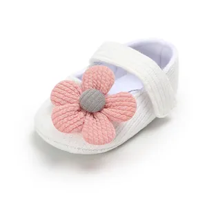 Macro view of the soft knit texture and handmade pink flower on white baby princess shoe