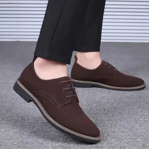 Gros plan sur des chaussures derby en daim marron pour hommes avec pantalon noir