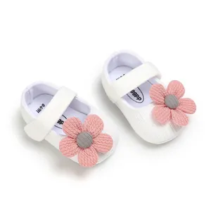 Detailed view of white knitted princess baby shoes with pink flower and soft anti-slip sole