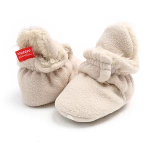 Close-up of beige fleece-lined warm baby winter booties with soft anti-slip soles