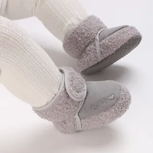 Detailed macro view of grey woolly baby snow boots featuring embroidered heart Baby logo.