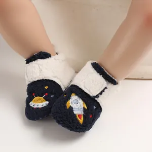 Close-up of baby walking shoes with rocket and UFO embroidery and soft fleece lining