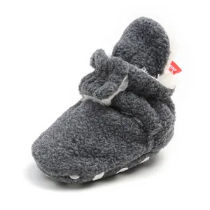 Detail view of grey fleece baby bootie with plush lining and red tag for winter warmth