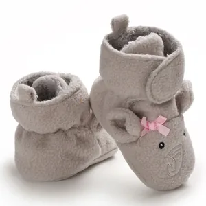 Dettaglio di scarpine per neonati in peluche con ricamo a elefante e fiocco rosa