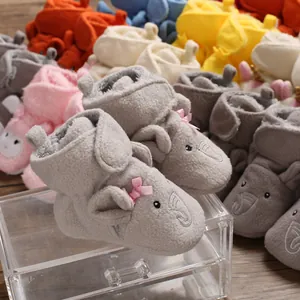 Primo piano di scarpine per neonati in pile grigio morbido con simpatico design a elefante