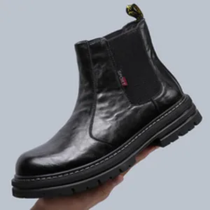 Détail de bottines Chelsea en cuir noir pour hommes avec semelle épaisse crantée.