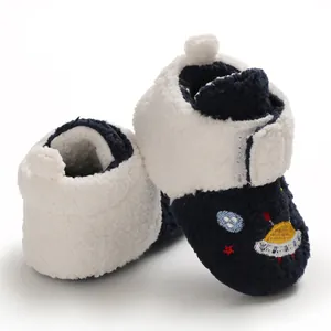 Close-up of cozy navy blue and white fleece-lined baby booties with UFO embroidery