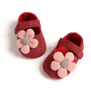 Detail showing the soft red knit texture and pink flower of these baby princess shoes.