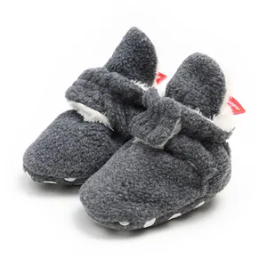Close-up detail of grey fleece baby walking booties with warm white faux fur lining