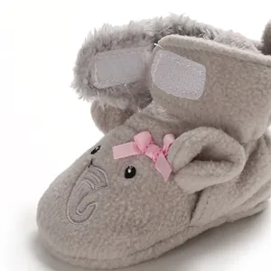 Dettaglio di scarpetta in pile grigio per neonato con ricamo elefante e fiocco rosa
