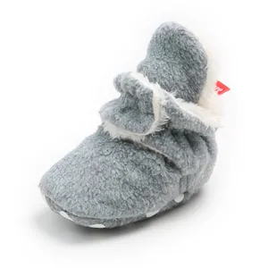 Close-up detail of grey fuzzy infant winter boots featuring warm white fleece lining